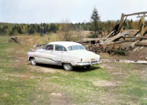 The Buick parked in front of the collapsed barn.