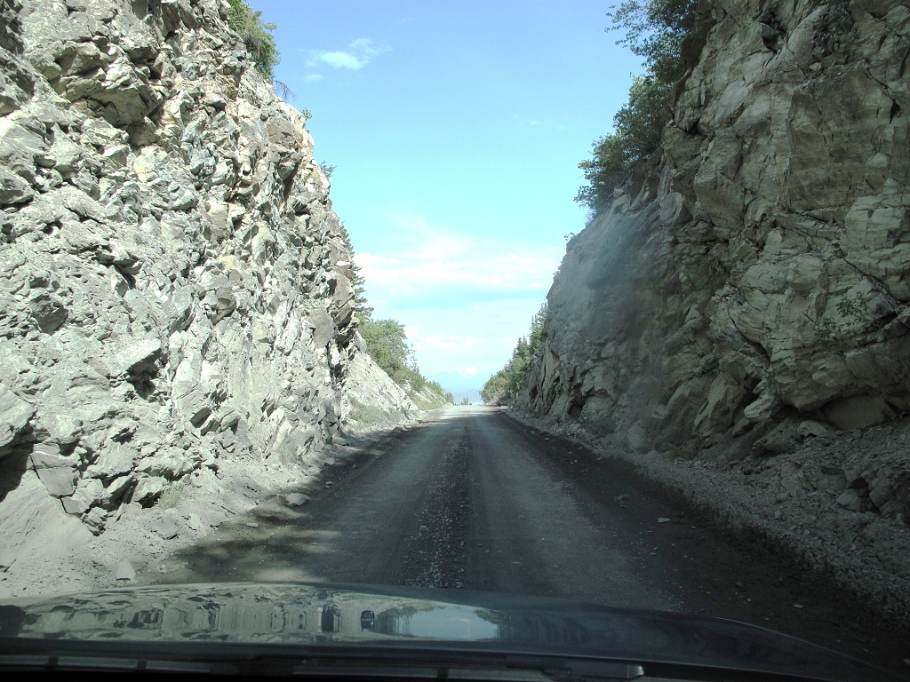The gravel road led through a narrow cut in the rock.